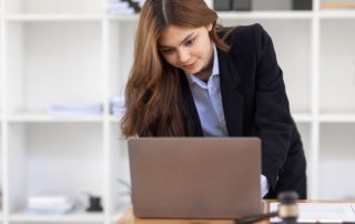 A Woman In A Suit Looking At Her Laptop